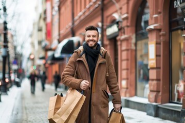 Obraz premium Happy joyful man with shopping bags in his hands