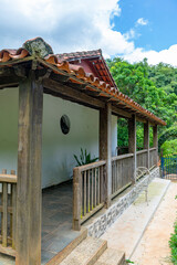 Large wooden farmhouse balcony overlooking the forest. Trees.