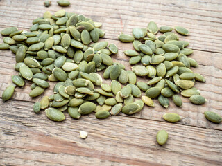 raw pumpkin seeds on a wooden background