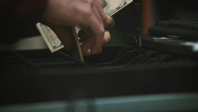 Person taking money from a cash register