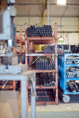 Metal steel square piping pipes stacked up on an industrial heavy duty racking in an industrial...