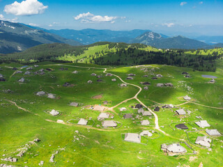 Aerial View of Mountain Cottages on Green Hill of Velika Planina Big Pasture Plateau, Alpine Meadow...