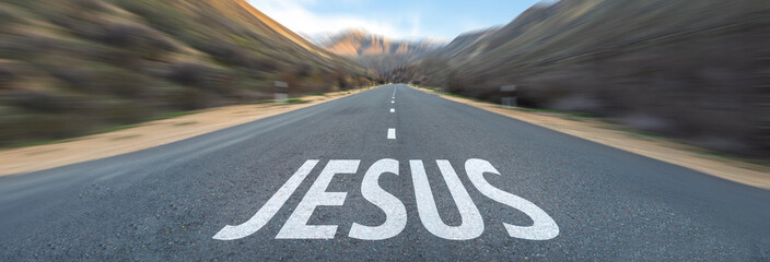 Asphalt road surrounded by mountains, Jesus written on the road. Christian concept. Jesus is the way