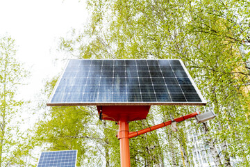 A solar panel sits atop an orange pole, harnessing solar energy