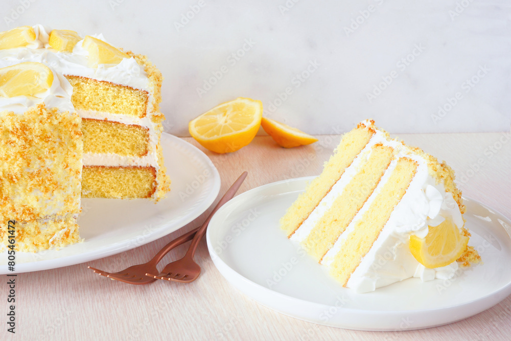 Poster Delicious lemon cake with creamy frosting. Side view table scene with slice removed against a bright background.
