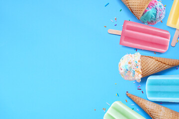 Assortment of colorful pastel ice cream cones and popsicle summer frozen desserts. Overhead view...