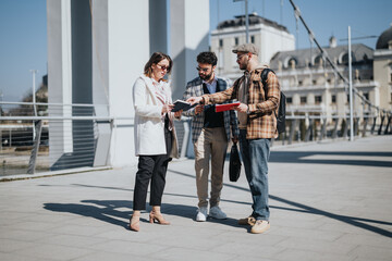 Three young business professionals collaborating on strategy outdoors with an urban cityscape in the background.