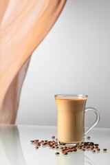 Coffee with cream on a glass table.