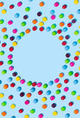 Sweet multicolored candies on a bright blue background, the shape of the sun. Minimal summer concept.	