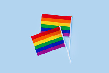 LGBT rainbow flag flat lay on light blue color background. gay marriage, human rights, june parade, lgbtq proud history month concept, coming out day. top view, place for text or logo