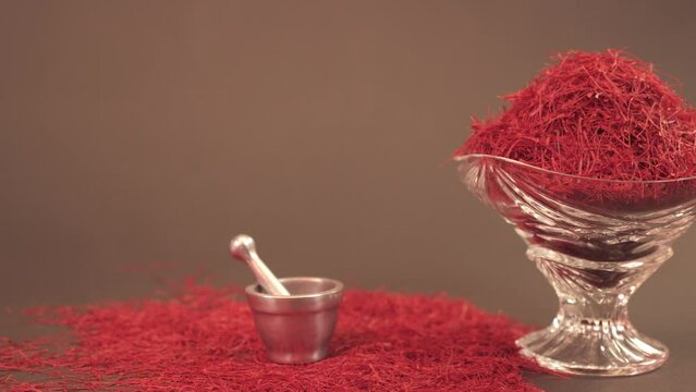 Saffron spice in a crystal bowl beside a silver mortar
