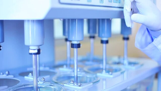 tablet dissolution test apparatus working condition close up. a scientific instrument dissolving tablets in a science instrumentation chemistry laboratory. tablet dissolving machine	