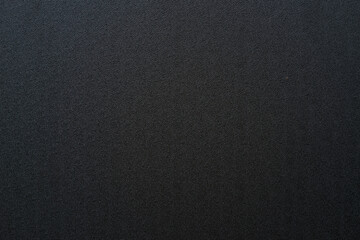 Photo of the texture of black ABS plastic. Black background with a high-resolution matte surface.