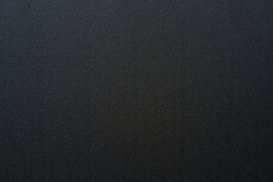 Photo of the texture of black ABS plastic. Black background with a high-resolution matte surface.