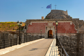 Bridge leading to entrance of Old Fortress in Kerkyra, Corfu, Greece, Greek flag waving above