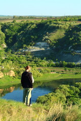 A man standing next to a pond