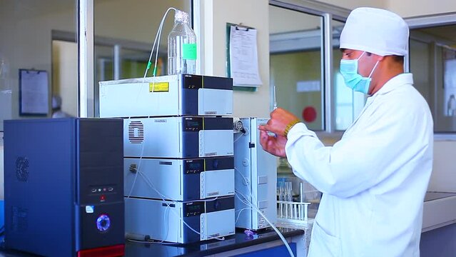 Close up of science experiment syringe inserting filling inside an HPLC machine inside view in a Scientific experimental laboratory for research development analysis.

