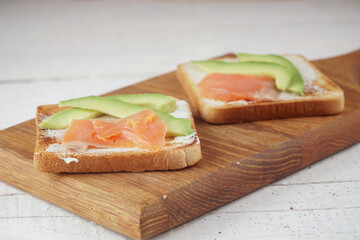 Toast with avocado and red fish. An exquisite breakfast of toast and flowers