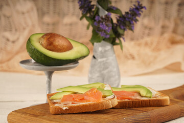 Toast with avocado and red fish. An exquisite breakfast of toast and flowers