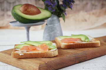 Toast with avocado and red fish. An exquisite breakfast of toast and flowers