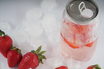 А transparent jar with a refreshing strawberry drink. Can with drink and ice
