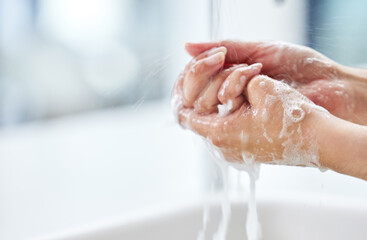 Woman, water and wash hands with soap for hygiene, germ protection and cleaning in bathroom....