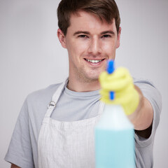 Man, portrait and studio for cleaning with spray bottle, happy and disinfectant liquid cleaner for...