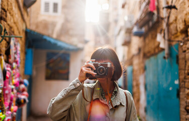 woman photographer with a camera takes pictures outdoors. A young female photographer aims the lens...