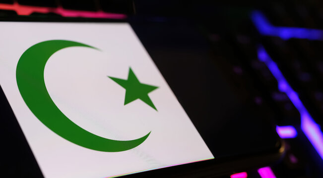 Crescent moon and star islam symbol on smartphone screen with computer keyboard (focus on center of moon)