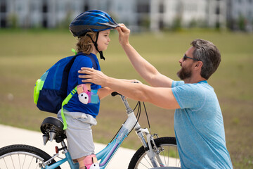 Insurance. Father teaching son riding bike. Dad helping child son to ride a bicycle in american...