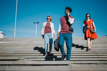 Obraz premium Three business professionals in casual clothes descend steps on a bright day, embodying an informal work environment.