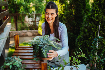 One young caucasian woman is taking care of her plants using plant mister and water can	
