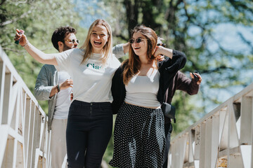 Joyful young adults walk across a bridge in a park on a sunny day, exuding happiness and...