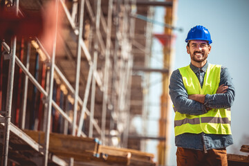 Construction site manager standing  wearing safety vest and helmet, thinking at construction site....