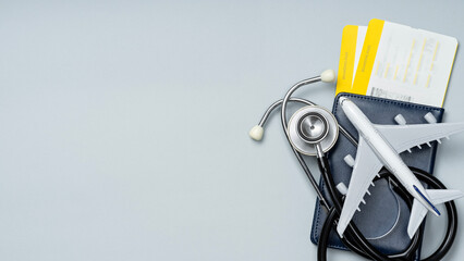 Airplane, stethoscope, passport and plane tickets. Health tourism and travel medical insurance. Copy space.
