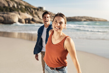 Couple, walking and holding hands on journey at beach in summer, holiday or portrait of vacation. Happy, travel and woman leading man with smile on face on island, sand and adventure in marriage