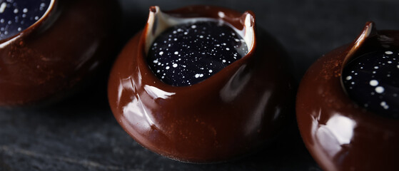 Chocolate candies on dark background, closeup