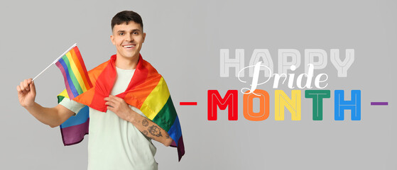 Handsome young happy man with LGBT flags on grey background