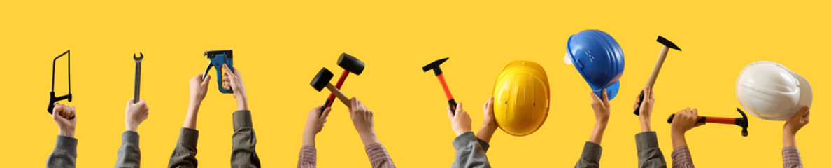 Female hands holding different construction tools on yellow background