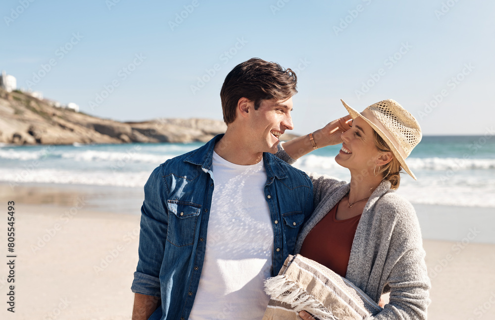 Wall mural Couple, love and relax at beach for vacation, summer and smile for anniversary in nature. Man, woman and happiness outdoor for travel, trust and sunshine by ocean for support, holiday and sea