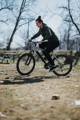 Fototapeta premium A focused young man rides his mountain bike through a tranquil park, exuding a sense of freedom and relaxation against a natural backdrop.