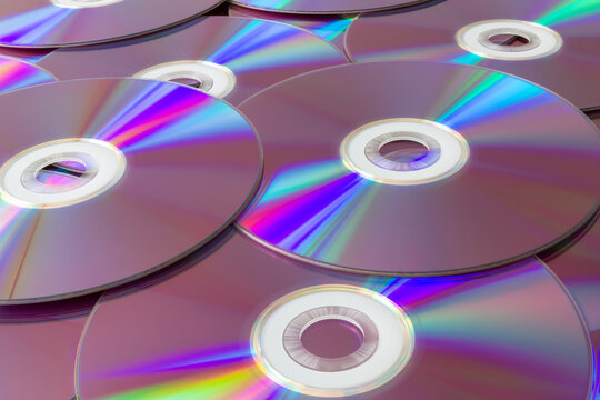 Rainbow reflections on a collection of compact discs. Vibrant stack of cds with iridescent reflections creating a spectrum of colors, representing data storage and digital technology.