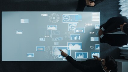 Diverse business people group discussing and brainstorming about marketing strategy with hologram of data analysis statistic or marketing investment graph while sitting at meeting room. Directorate.