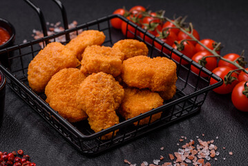 Delicious fresh crispy chicken nuggets on a dark concrete background