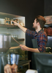 Business owner, working and stock in coffee shop for management, quality control and compliance. Entrepreneur, startup and inventory checklist in cafe for report, administration and supply chain