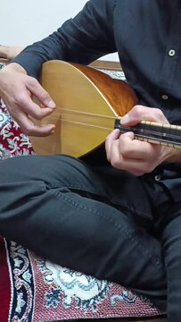 A folk singer who plays saz with his hand.