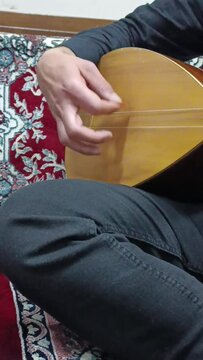 A folk singer who plays saz with his hand.