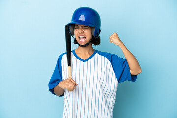 Baseball mixed race player woman with helmet and bat isolated on blue background doing strong gesture