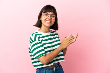 Young mixed race woman isolated on pink background applauding