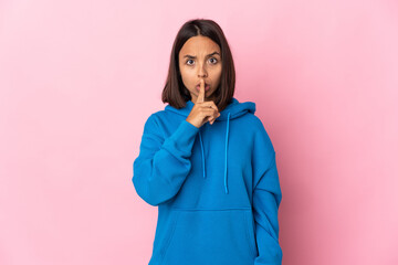 Young latin woman isolated on pink background showing a sign of silence gesture putting finger in...